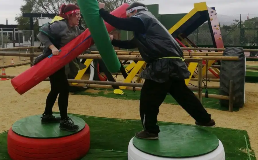 Dos participantes luchando sobre plataformas en el circuito